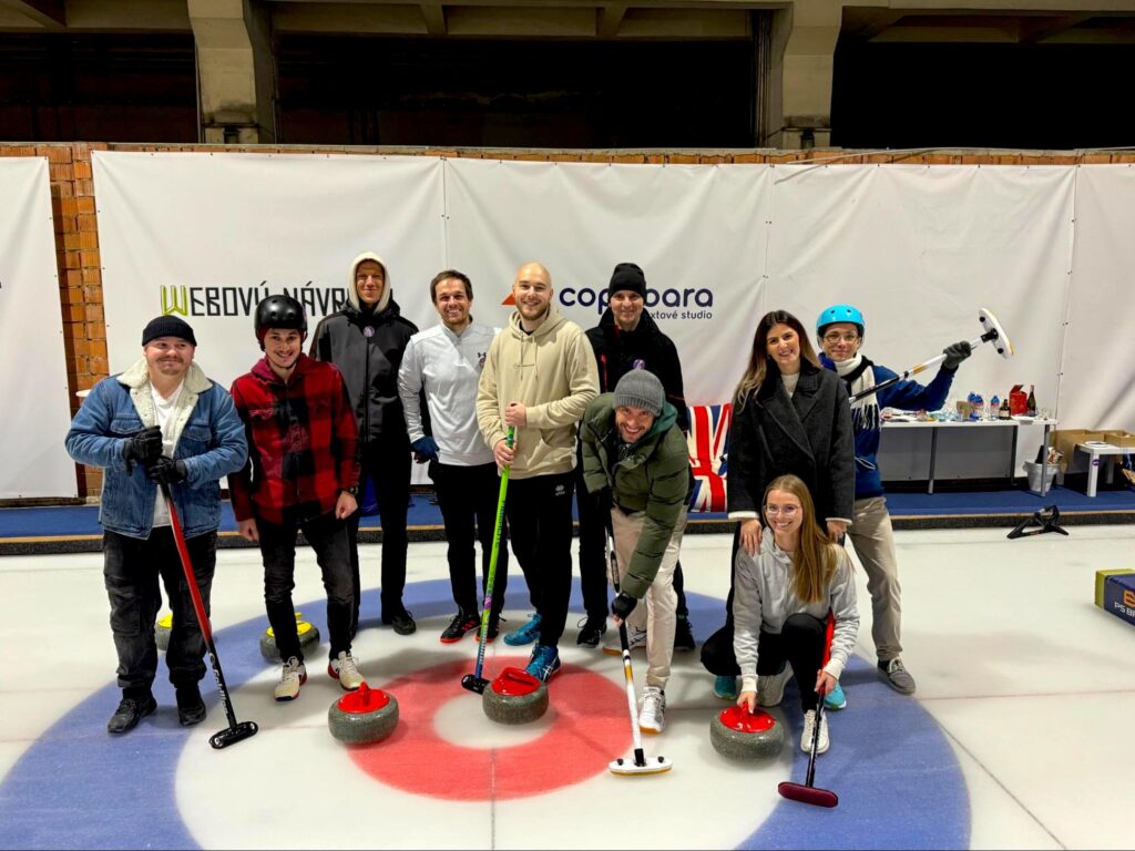 Ten primehammer members pose for a photo at a curling venue.
