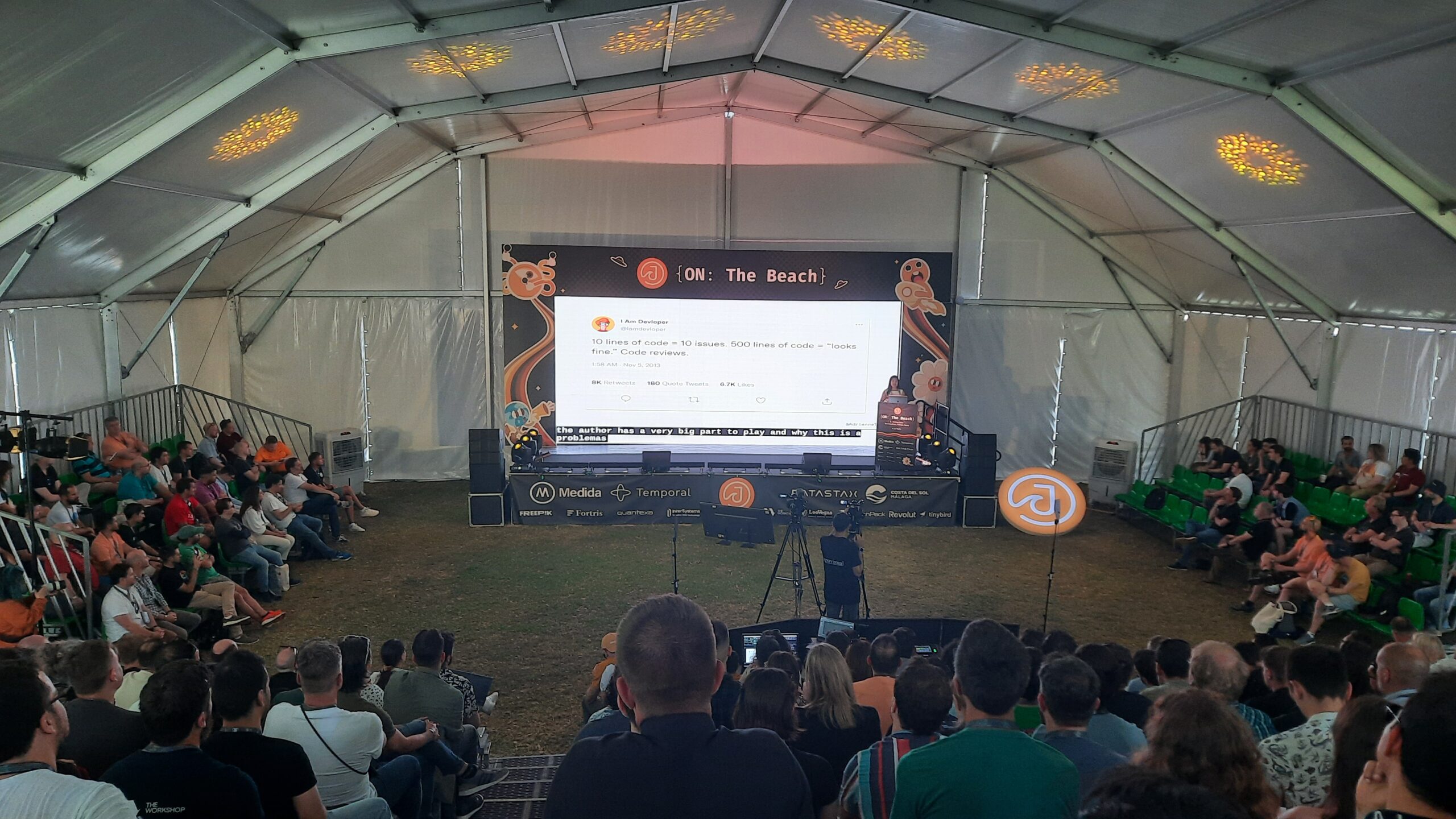 A group of engineers sit around a big screen projecting notes from the J On The Beach workshop.